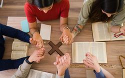 lidé držící se za ruce při modlitbě, foto: Freepik.com